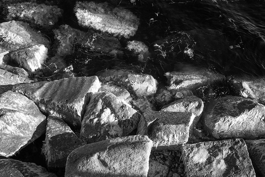 Infrared Photo of Brutally Textural Rocks at the Water's Edge.